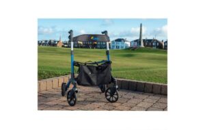 Alerta Aluminium Foldable Rollator, fully assembled on hardstanding with a grassy area behind, a building in the distance and blue skies