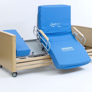 The Apollo Saturn Rotate Bed is in the chair position and the bed is tilting forward which allows the person to stand more easily. Bed frame is a light wood colour and the mattress has a blue vp cover. White background.