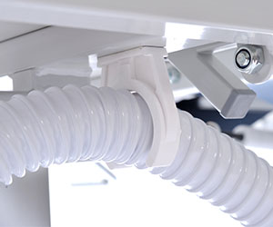 Close up of the flexi hose that comes with the Timo Electric Shower Trolley. Image shows the hose being clipped underneath so as to avoid any trip hazard.
