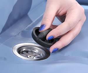 close up of a hand inserting the removable plug into the shower trolley liner