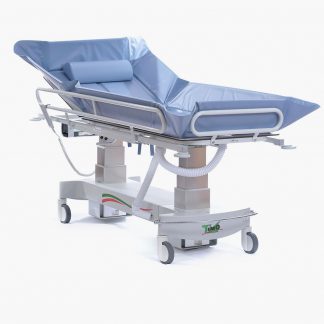 Timo Electric Shower Trolley raised to its full height with side rails in place and a light blue mattress and head pillow