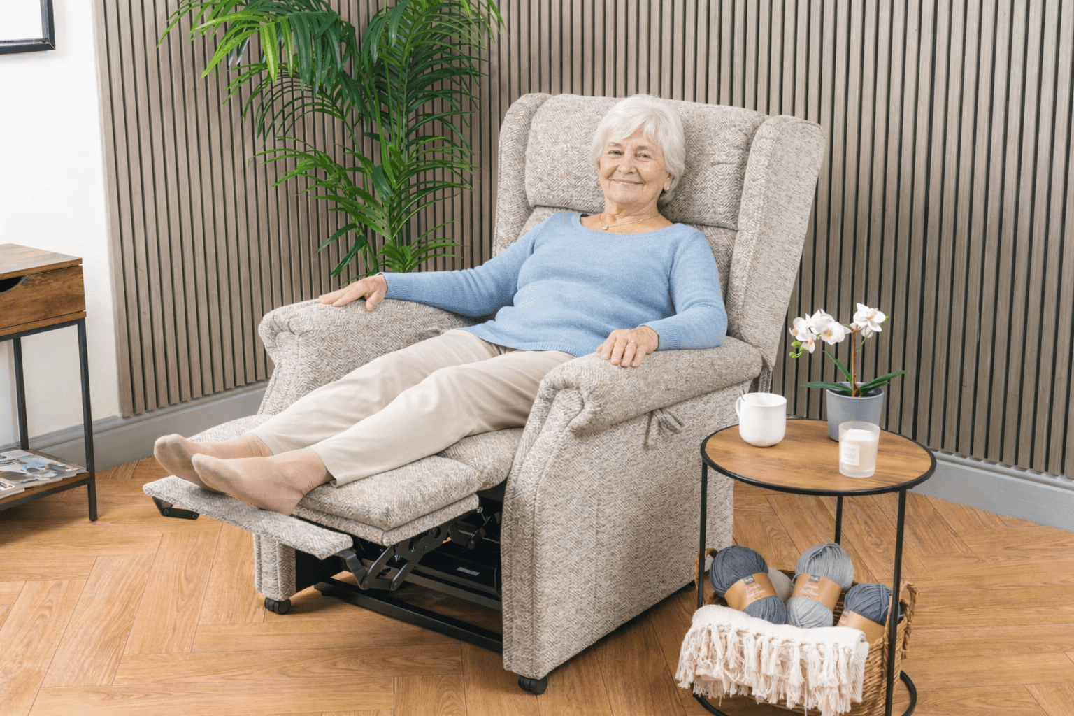 Older woman relaxing in a riser recliner chair with leg rest elevated